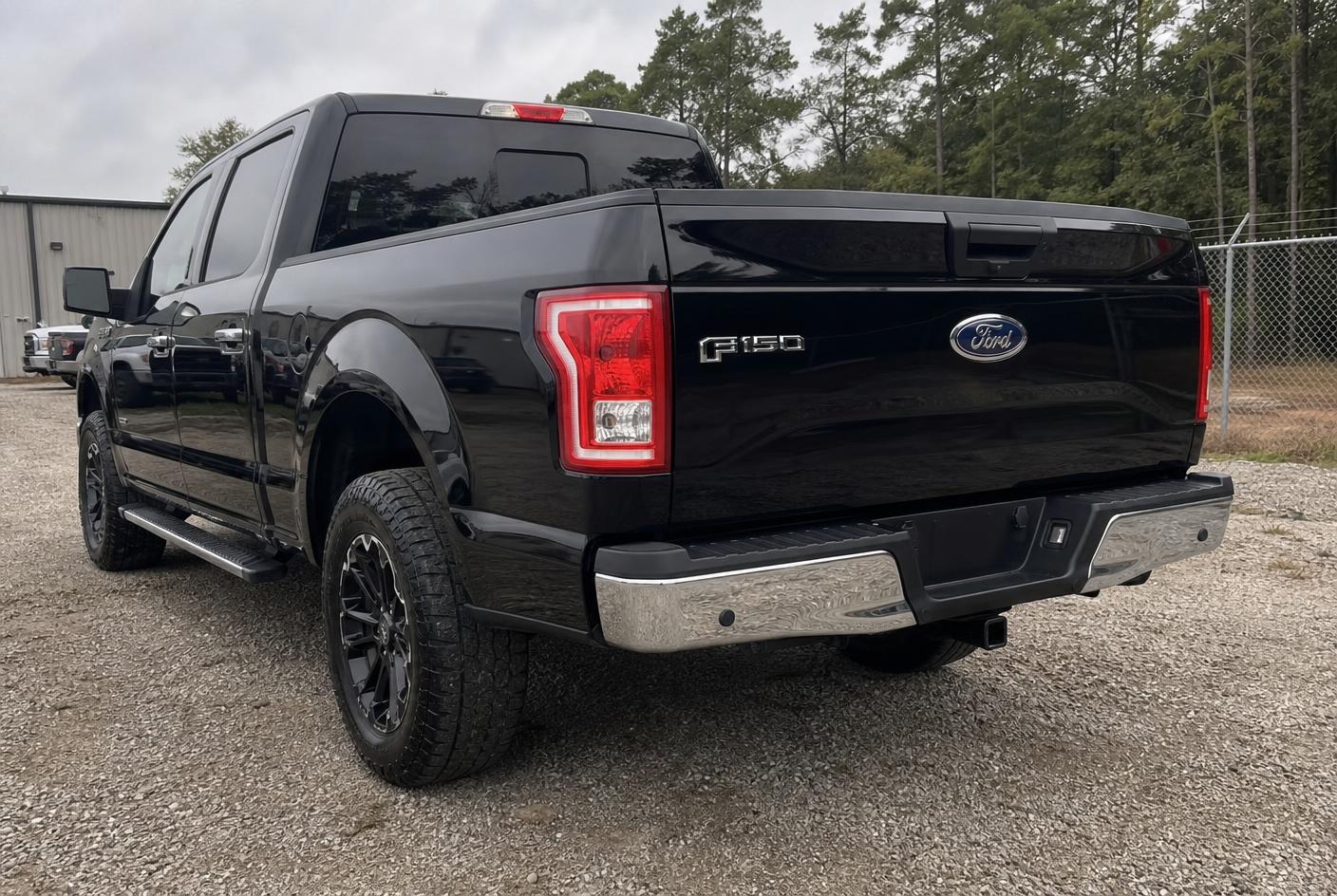 The same black pickup truck after tailgate, bumper and paint restoration